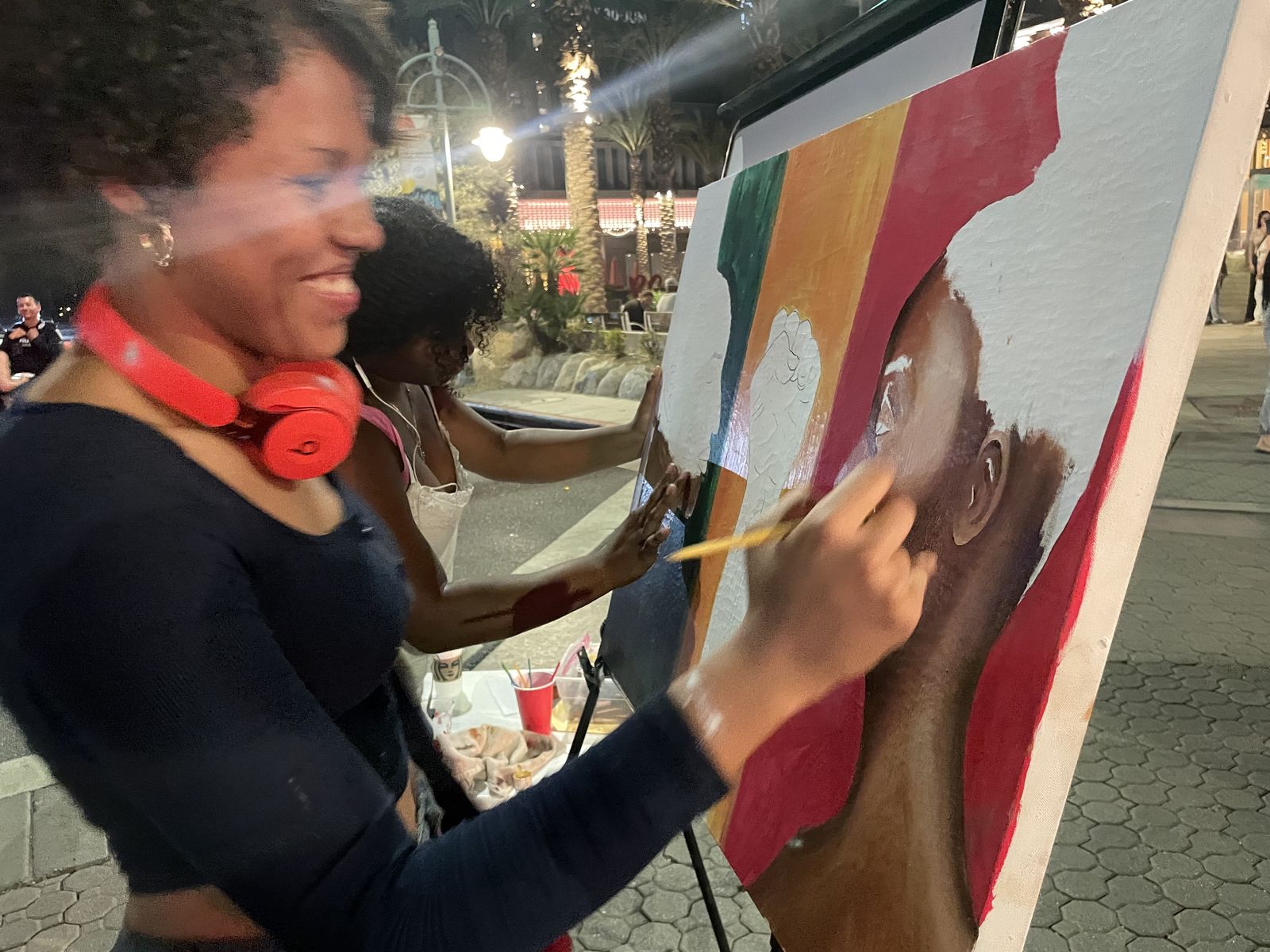 Mariah painting a portrait live at a night event